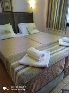 Habitación de hotel con 2 camas y toallas. en Menelaos Apartments, en Lefokastro