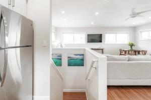 a white living room with a couch and a kitchen at Ko'olau Escape on Kaneohe Bay Private Guest Suite with Full Kitchen & AC in Kaneohe