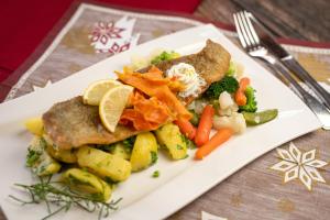 a plate of food with fish and vegetables on a table at Gasthof Pension Orthofer in Sankt Jakob im Walde