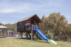 a playground with a slide and a house at Medronho D'Ouro bungalows in Foz do Sousa