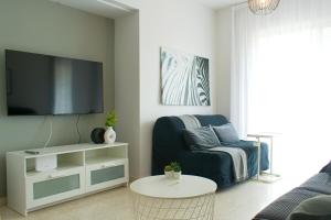 a living room with a couch and a tv at ALEX APARTMENT in Strovolos