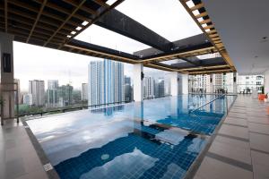 a swimming pool on the roof of a building with a city at Brittany Hotel BGC in Manila