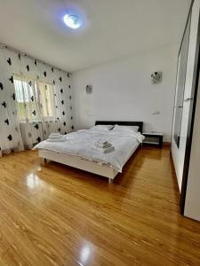 a bedroom with a bed and a wooden floor at Casa Rus in Leordina