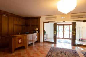 a living room with wooden walls and a large entry door at Antica Fornace Relais by La Principina in Principina Terra