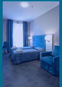 1 dormitorio con 1 cama azul y 1 sofá azul en Albergo MP Noli, en Noli