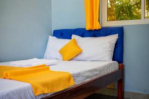 niebieski pokój z łóżkiem z pomarańczowym kocem w obiekcie Inkaba Resort & Conference Centre Kilifi w mieście Kilifi