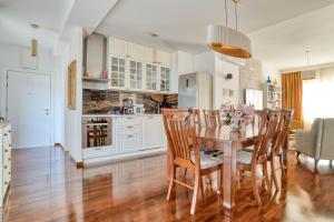 kuchnia i jadalnia z drewnianym stołem i krzesłami w obiekcie Ivanovic residences w Budvie