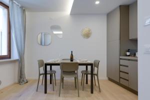 a kitchen and dining room with a table and chairs at PIENO CENTRO STORICO Nuovo appartamento "SARPI" in Udine