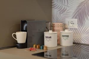 a shelf with cups and a coffee maker on it at PIENO CENTRO STORICO Nuovo appartamento "SARPI" in Udine