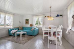 uma sala de estar com um sofá azul e uma mesa em Veslestua - Beach Bliss & Fishing Fun em Hemnes