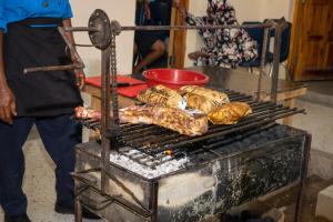 Mężczyzna gotuje jedzenie na grillu. w obiekcie Inkaba Resort & Conference Centre Kilifi w mieście Kilifi