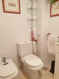 a white bathroom with a toilet and a sink at Apartamento con garaje. Luminoso y confortable in Santander