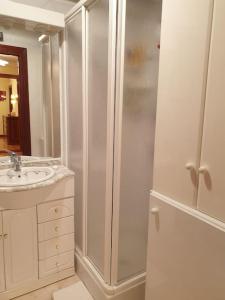 a white bathroom with a shower and a sink at Apartamento con garaje. Luminoso y confortable in Santander