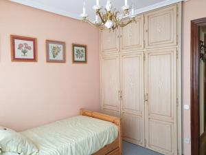 a bedroom with a bed and a chandelier at Apartamento con garaje. Luminoso y confortable in Santander