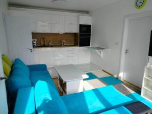 a living room with a blue couch and a kitchen at Alinik Apartment in Sofia