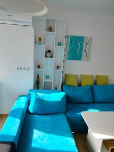a blue couch sitting in a living room at Alinik Apartment in Sofia