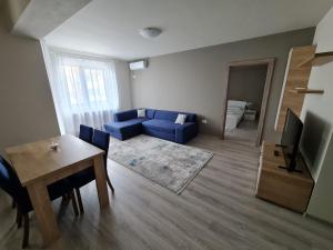 a living room with a blue couch and a table at Septimius Severus Apartments in Alba Iulia