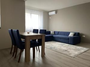 - un salon avec une table et un canapé bleu dans l'établissement Septimius Severus Apartments, à Alba Iulia