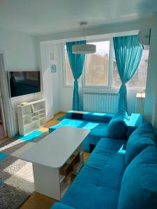 sala de estar con sofá azul y mesa en Alinik Apartment en Sofía