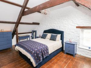 a bedroom with a bed and a brick wall at 2 Ashgrove in Dinas