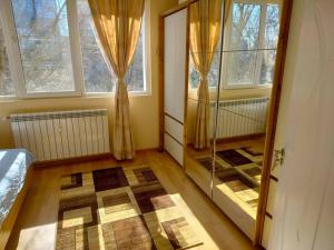 Zimmer mit einem Schlafzimmer mit Fenstern und einem Spiegel in der Unterkunft Alinik Apartment in Sofia