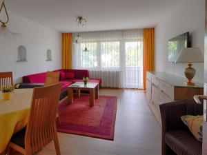 een woonkamer met een rode bank en een tafel bij Ferienwohnungen Rosenstraße in Langenargen