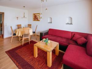 sala de estar con sofá rojo y mesa en Ferienwohnungen Rosenstraße, en Langenargen