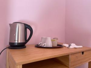 a tea kettle and cups on a wooden table at La Casa di Giulia in Sarnano