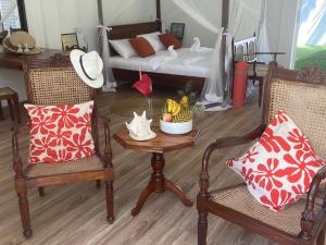 un soggiorno con 2 sedie e un tavolo con un letto di CJ's House at Mawella a Ihalagoda