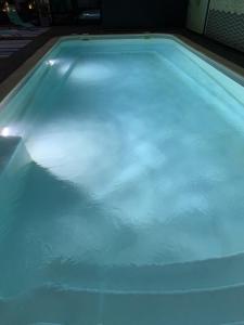 - une piscine avec des lumières bleues au-dessus dans l'établissement La Metairie-du-Vauhariot - Chambre Ou Lodge - Piscine Chauffée - Vue Mer et Mont Saint Michel - GR34, à Cancale
