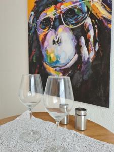 zwei Weingläser auf einem Tisch vor einem Gemälde in der Unterkunft studio d'henri in Agen