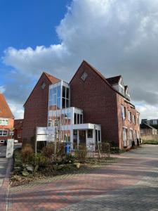 budynek z czerwonej cegły ze szklanymi oknami na ulicy w obiekcie Nieman‘s Loft w mieście Emden