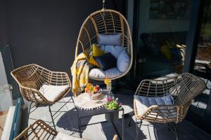 weranda z dwoma wiklinowymi krzesłami i stołem w obiekcie Apartment Skyline w mieście Cavtat