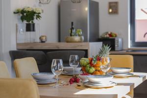 stół z kieliszkami do wina i koszem ananasów w obiekcie Apartment Skyline w mieście Cavtat