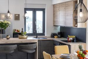 kuchnia z drewnianymi szafkami i stołem z krzesłami w obiekcie Apartment Skyline w mieście Cavtat