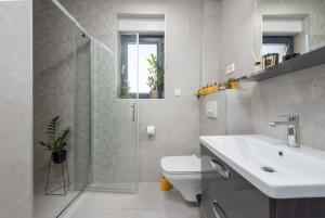 a bathroom with a toilet and a sink and a shower at Apartment Skyline two-bedroom apartment with balcony in Cavtat +34 photos