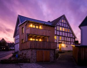 a large wooden house with lights on at Gästeappartements Mechels in Wilnsdorf