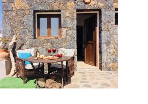 a table and chairs in front of a stone building at Lovely Cottage in La Oliva