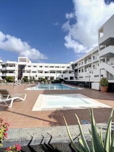a large apartment building with a swimming pool at Villa Rosa Gadis in Costa Teguise