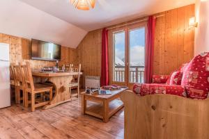 un salon avec un canapé et une table dans l'établissement Madame Vacances Les Chalets du Berger Premium***, à La Féclaz