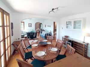 Casa Bellota في كالونج: غرفة طعام مع طاولة وكراسي خشبية
