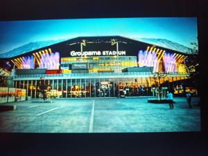 a large building with lights on the front of it at Appartement entier Cozy Rdj Parking gratuit, proche tramway, stade OL, ARENA, Eurexpo, Aéroport StExupéry, Gare TGV Lyon Partdieu in Décines-Charpieu +29 photos