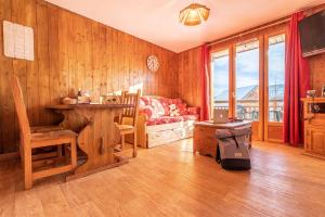 a living room with a couch and a table at Madame Vacances Les Chalets du Berger Premium*** in La Féclaz