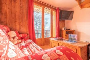 a living room with a couch and a laptop on a table at Madame Vacances Les Chalets du Berger Premium*** in La Féclaz
