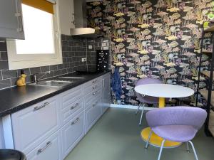a kitchen with a table and two purple chairs at Sfeervol guesthouse, privé tuin en free parking in Rotterdam