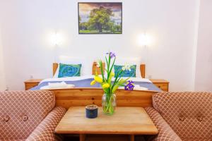 a bedroom with a bed and a vase of flowers on a table at Retel Vitez Vendégház in Sárospatak