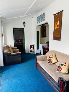 a living room with a couch and blue carpet at Zion White House in Nuwara Eliya