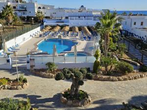 een resort met een zwembad en palmbomen bij Hotel El Puntazo I in Mojácar