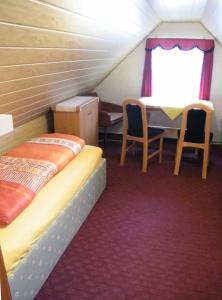 a room with a bed and a table and chairs at Ferienwohnung Bibas in Kurort Jonsdorf