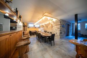 comedor con mesa, sillas y pared de piedra en Villa Valtin en Le Valtin